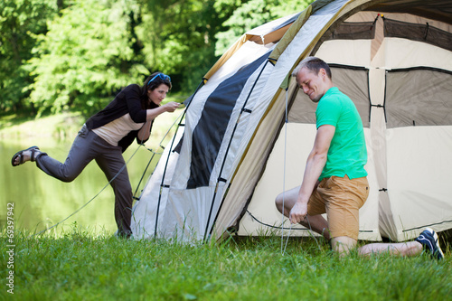 Bilde på lerret Couple trying to pitch a tent