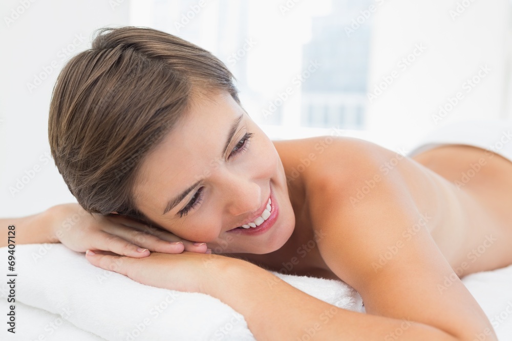 Beautiful woman lying on massage table at spa center