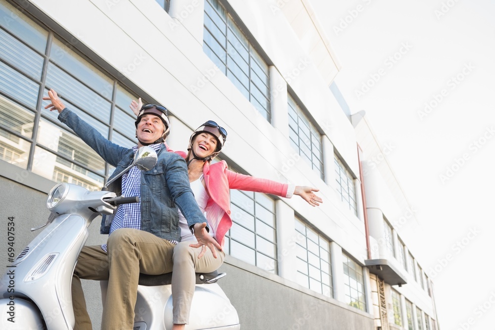 Happy senior couple riding a moped Happy senior couple riding a moped