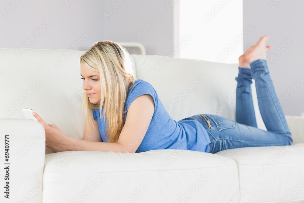 Relaxed beautiful woman text messaging in living room Relaxed beautiful woman text messaging in living room