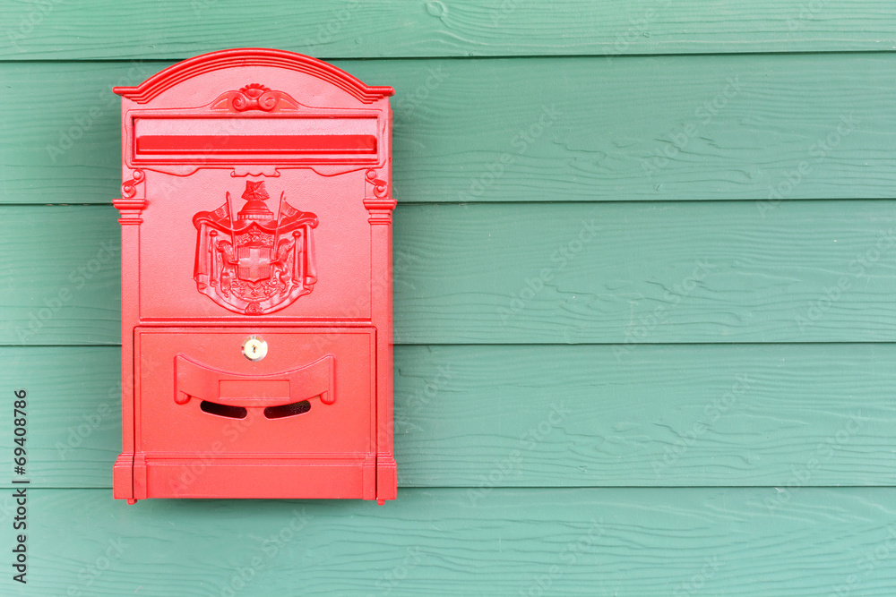 Red mailbox with green wood background Red mailbox with green wood background