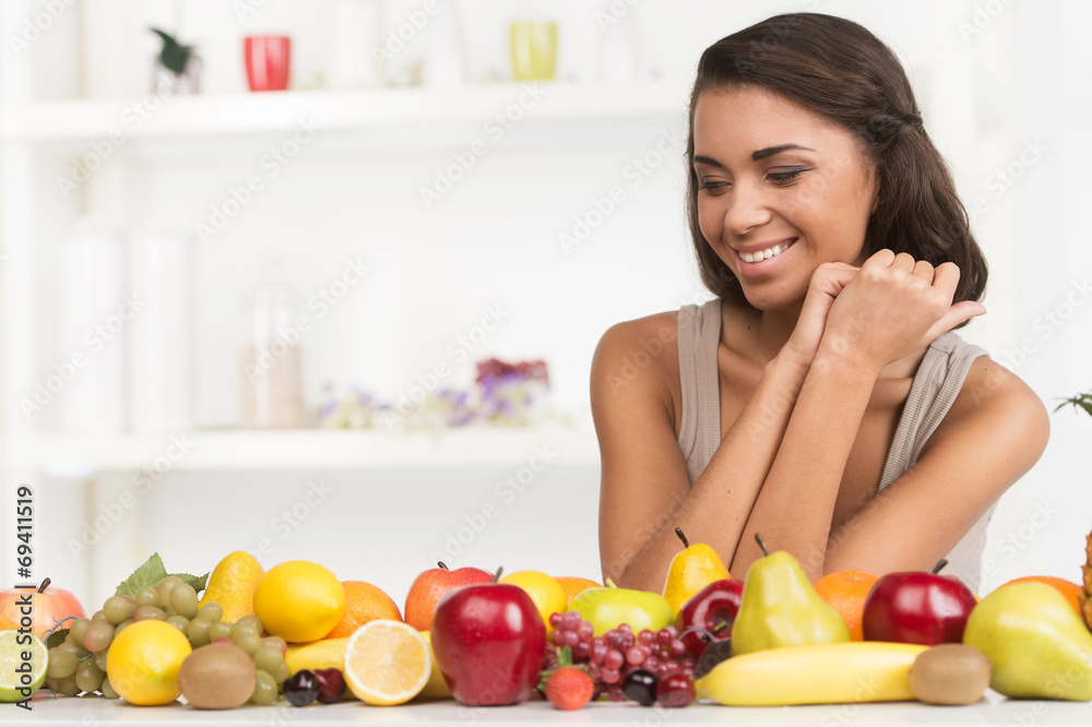 Beautiful woman looking at fruits on table. Beautiful woman looking at fruits on table.