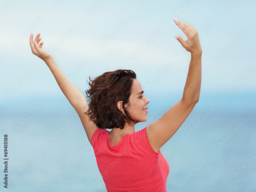 Beautiful young woman enjoying summer with her arms outstretched Beautiful young woman enjoying summer with her arms outstretched