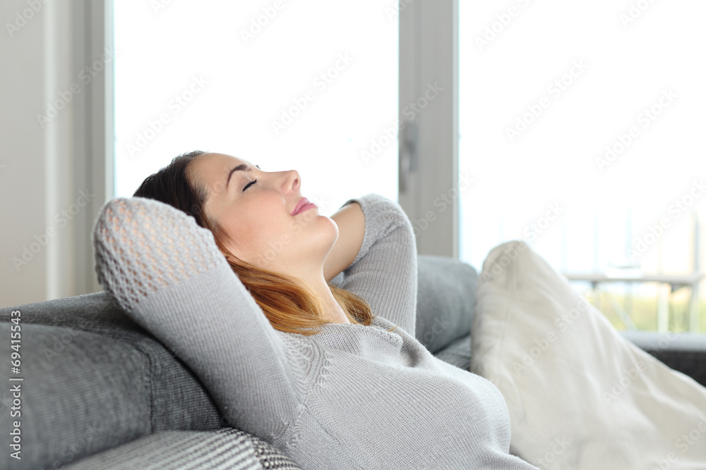 Happy relaxed woman resting on a couch at home Happy relaxed woman resting on a couch at home