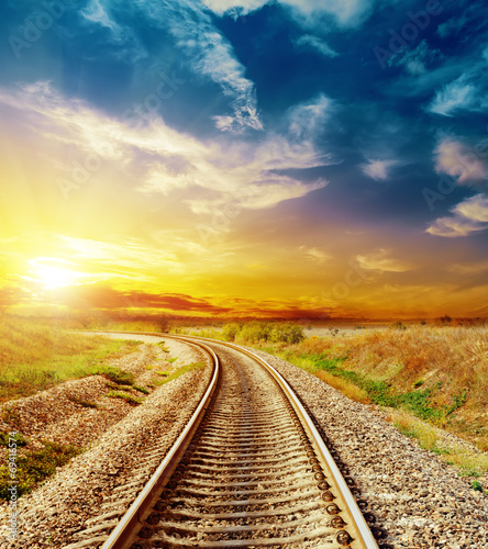 good sunset in colored sky over railroad