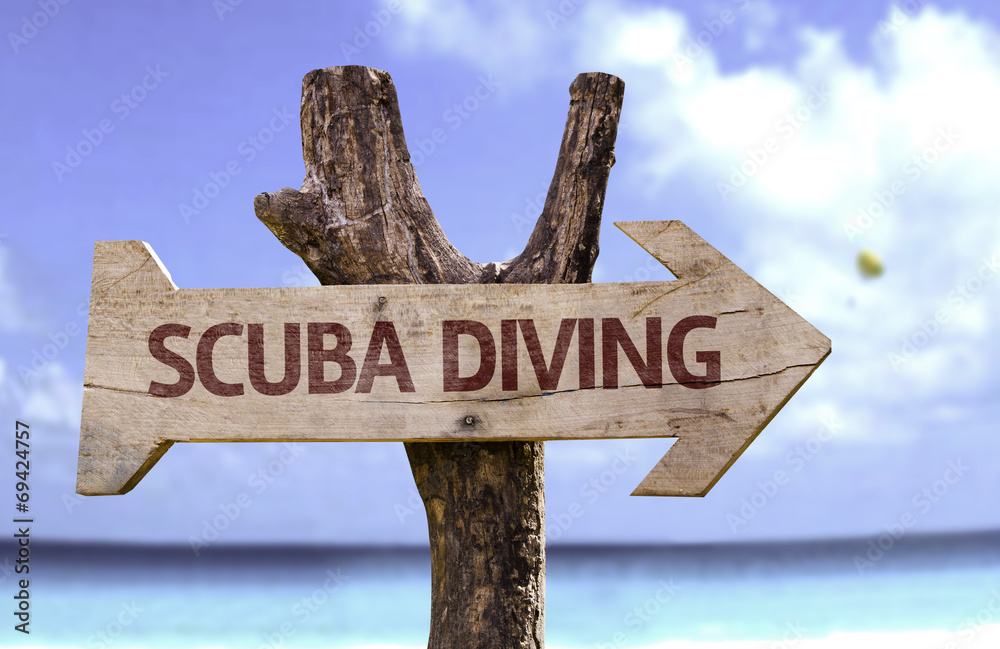 Scuba Diving wooden sign with a beach on background