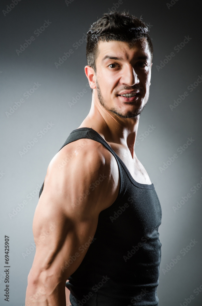 Muscular man posing in dark studio Muscular man posing in dark studio