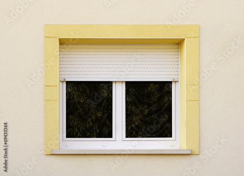 Modernes Fenster mit Rollladen und gelber Fenstereinfassung photo