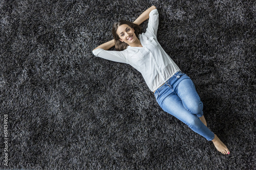 Young woman laying on the carpet photo