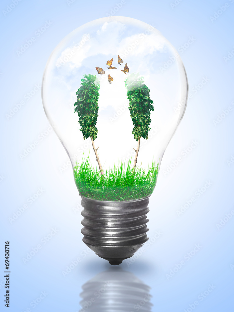 Natural energy concept. Lightbulb with summer meadow, trees and Natural energy concept. Lightbulb with summer meadow, trees and