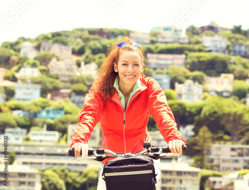Happy woman riding on bike on a summer day, Sausalito town