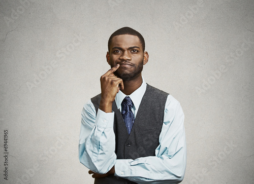 Man skeptic, confused, thinking isolated on grey wall background
