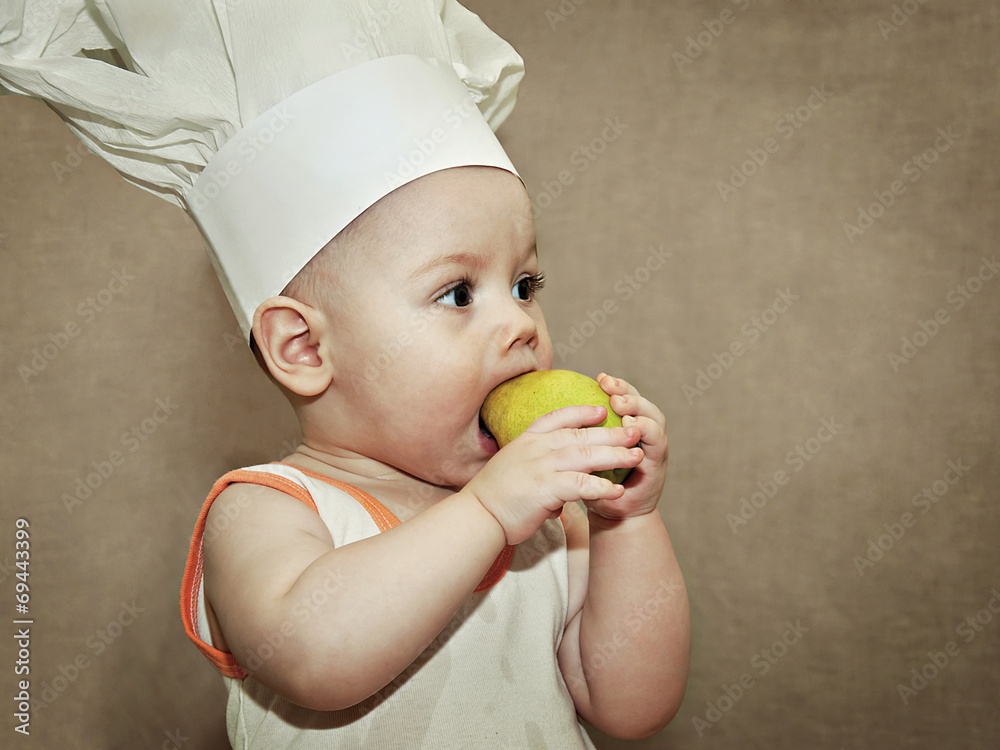 little baby in a chef's hat eating a pear little baby in a chef's hat eating a pear