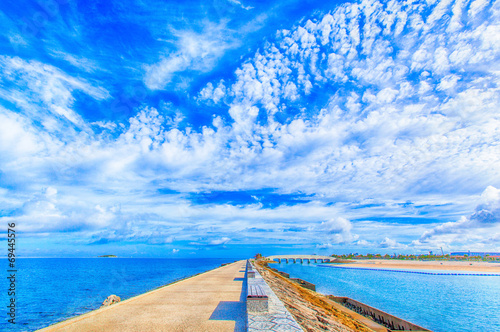 Breakwater with benches and blue sky © shihina