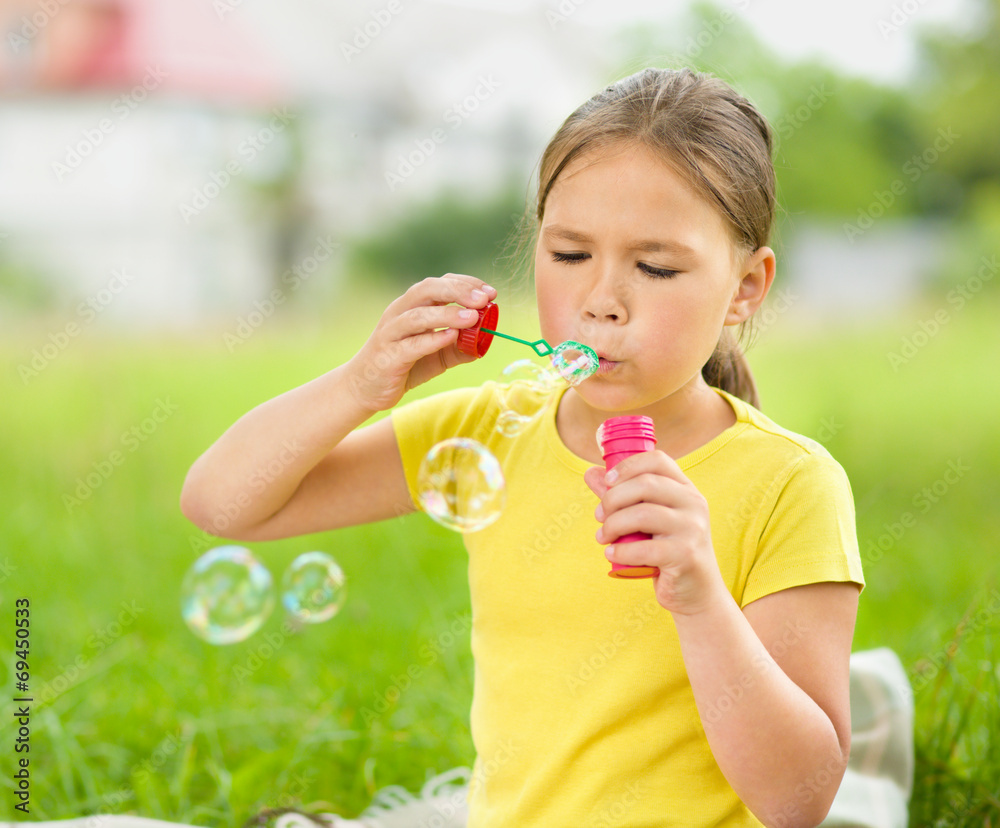 Little girl is blowing a soap bubbles Little girl is blowing a soap bubbles