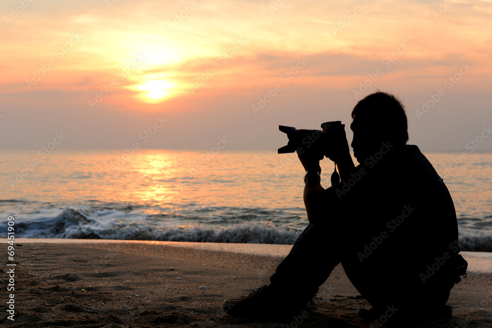 Silhouette photographer sitting on the beach