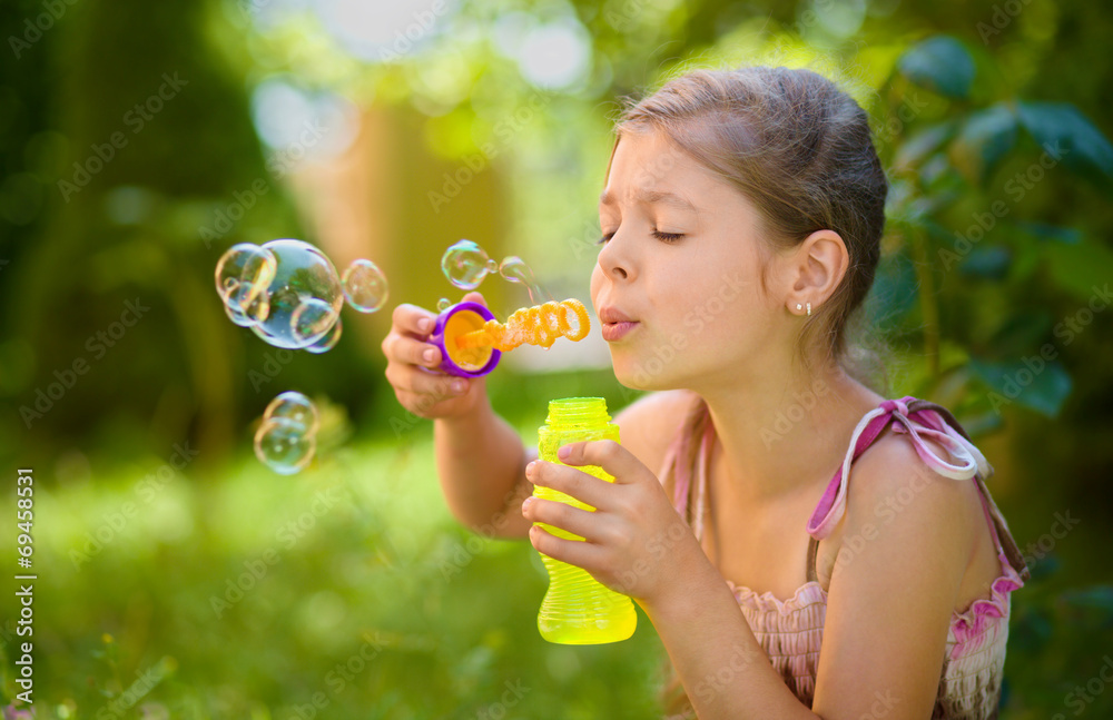 Little girl is blowing a soap bubbles Little girl is blowing a soap bubbles