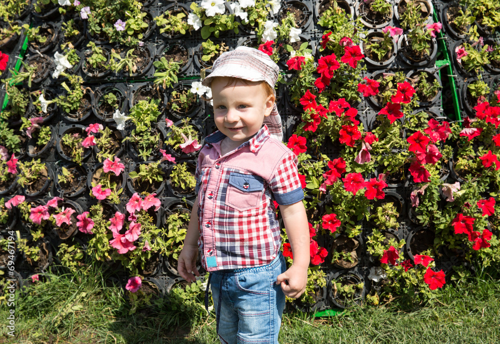 Cute little child boy in park on nature at summer.
