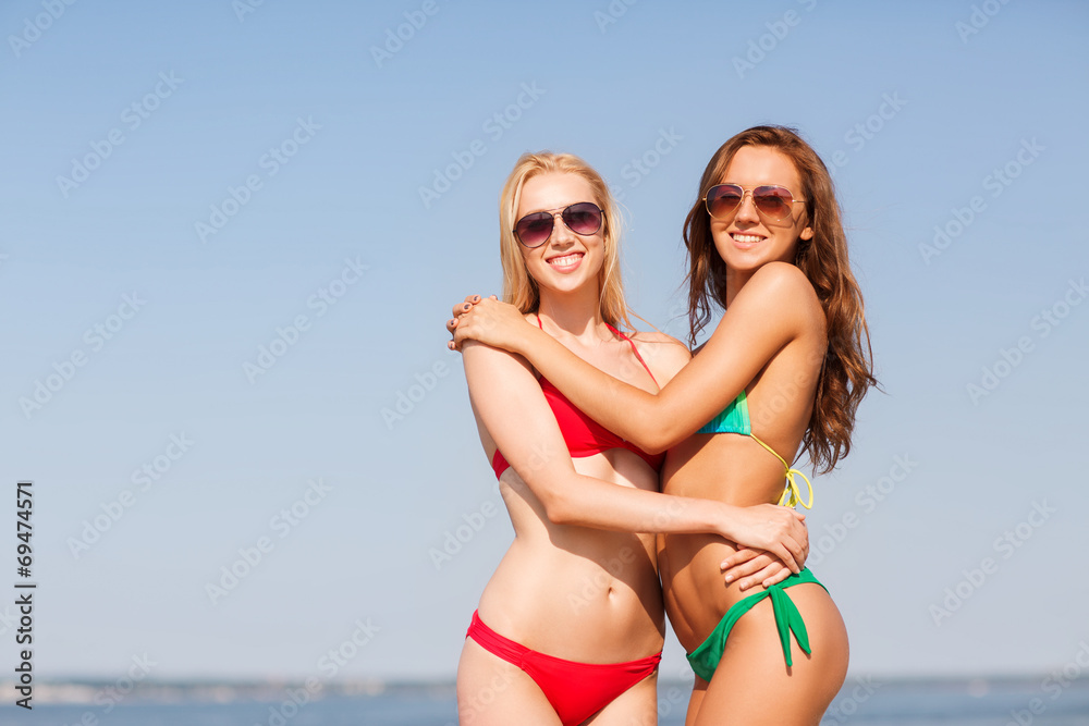 two smiling young women on beach
