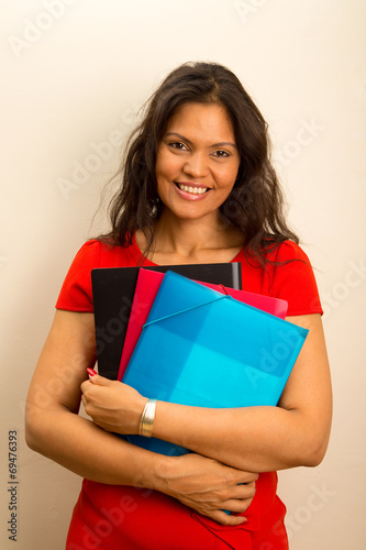 beautiful latina holding folders.