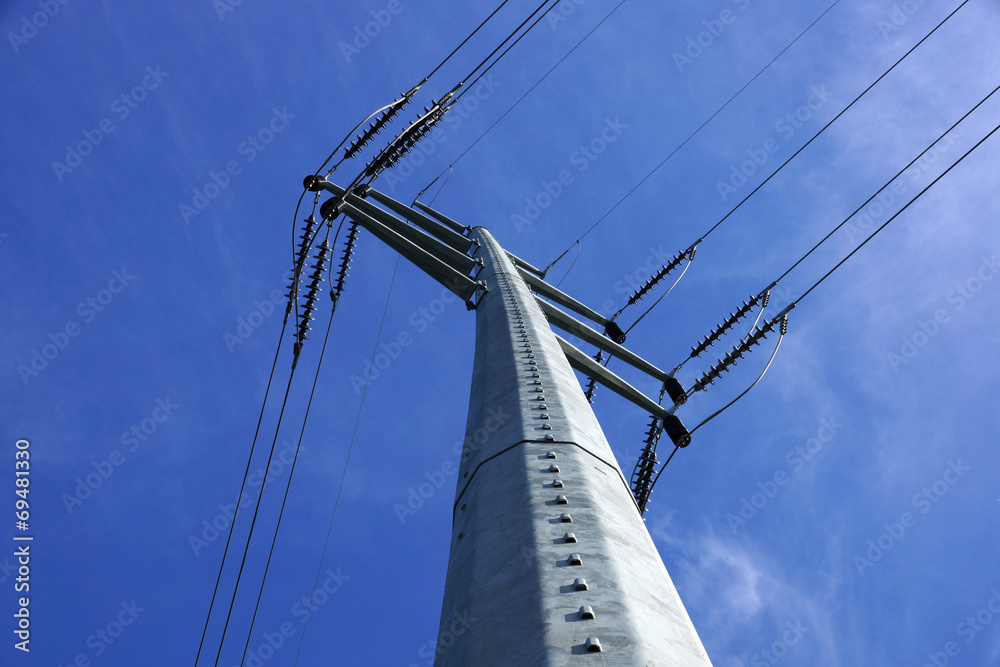 Fototapeta premium High Voltage Power Lines intersect at a large metal Utility pole