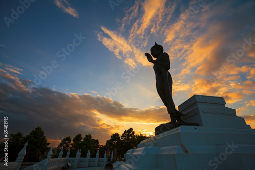Standing Buddha image silhouette on sunset sky. in Phitsanulok 