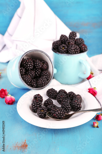 Sweet blackberries in mugs and
