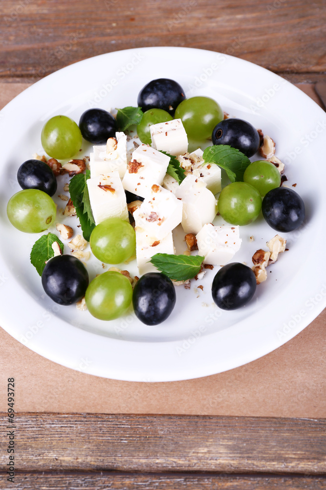 tasty salad with grape and cheese on wooden table tasty salad with grape and cheese on wooden table