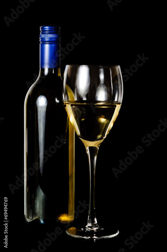 A glass and blue rit bottle of white wine