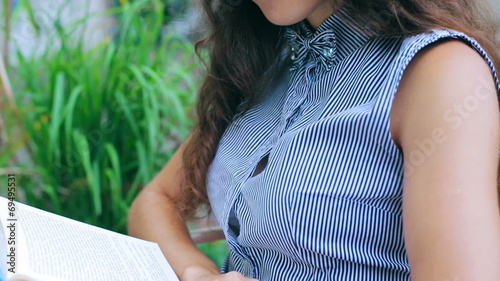 Woman enjoying reading interesting book in the street restaurant photo