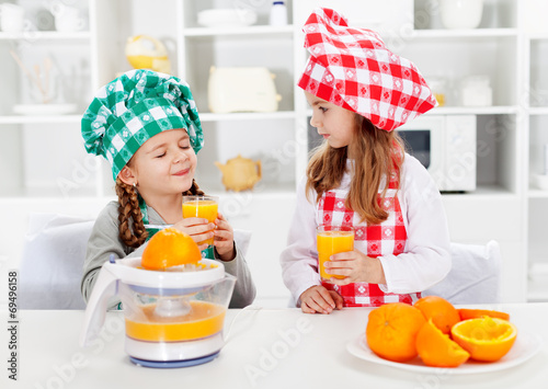 Little chef girls tasting the orange juice they made
