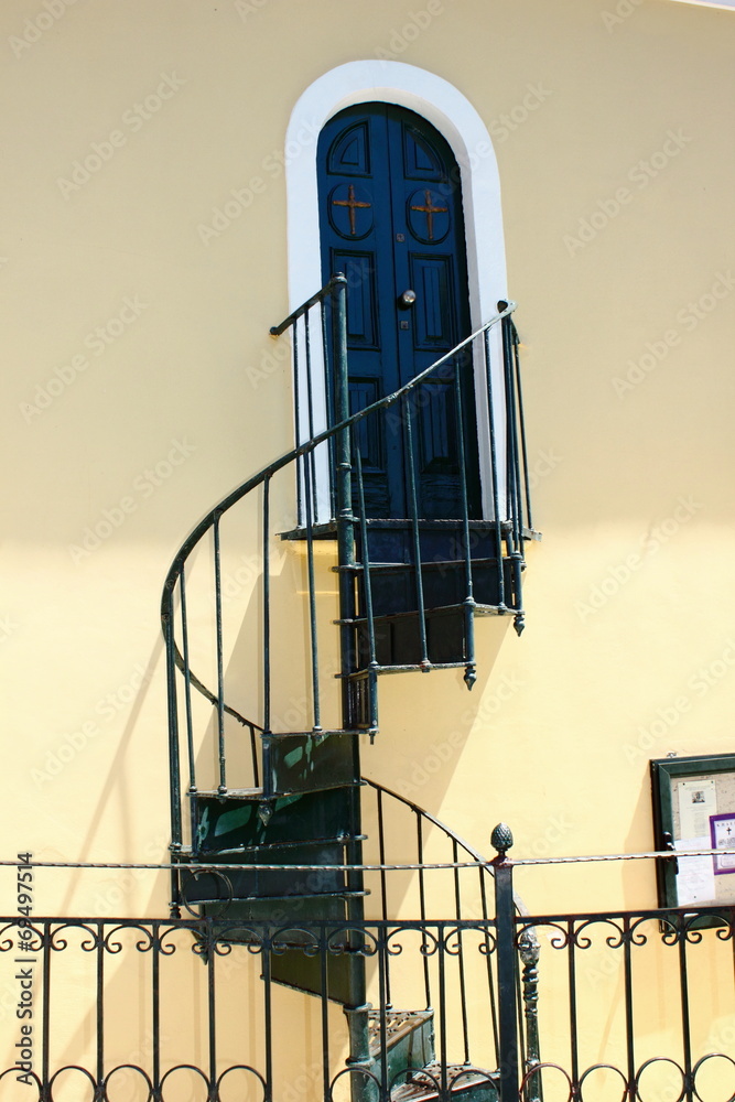 metal spiral steps and staircase up to a door - obrazy, fototapety, plakaty 
