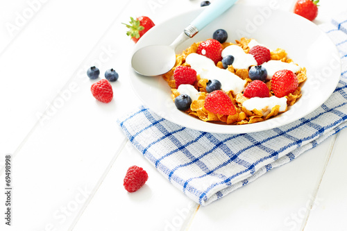 Corn flakes with yogurt and berries on plate