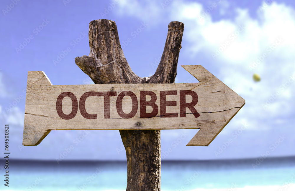October wooden sign with a beach on background