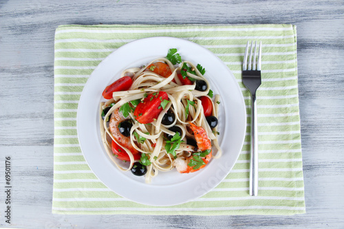 Fresh prawns with spaghetti, olives, tomatoes and parsley in a