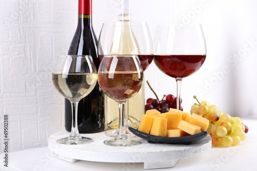 Bottles and glasses of wine, cheese and ripe grapes