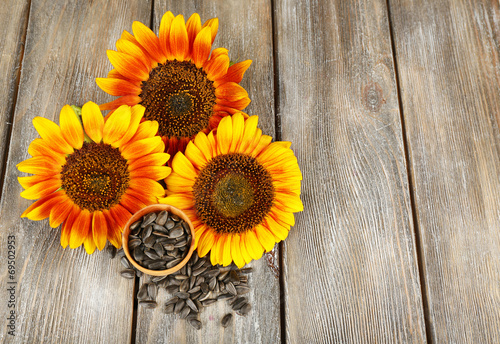 Fototapeta Naklejka Na Ścianę i Meble -  Sunflowers and seeds in bowl on wooden background