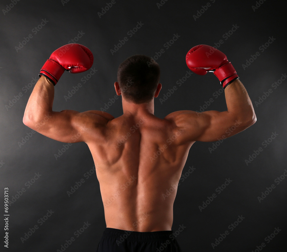Handsome young muscular sportsman with boxing gloves