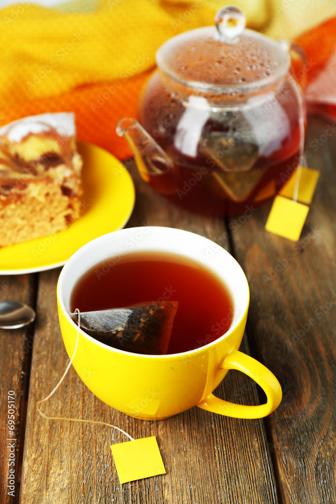 Cup with tea, teapot and tea bags on wooden table close-up Cup with tea, teapot and tea bags on wooden table close-up