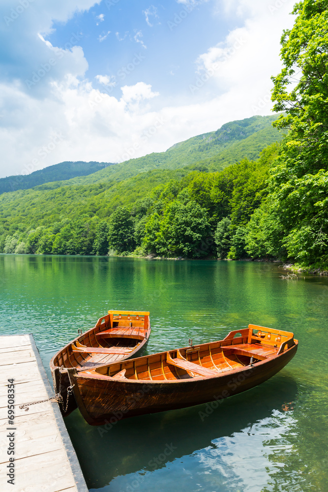 Wooden boats at pier on mountain lake