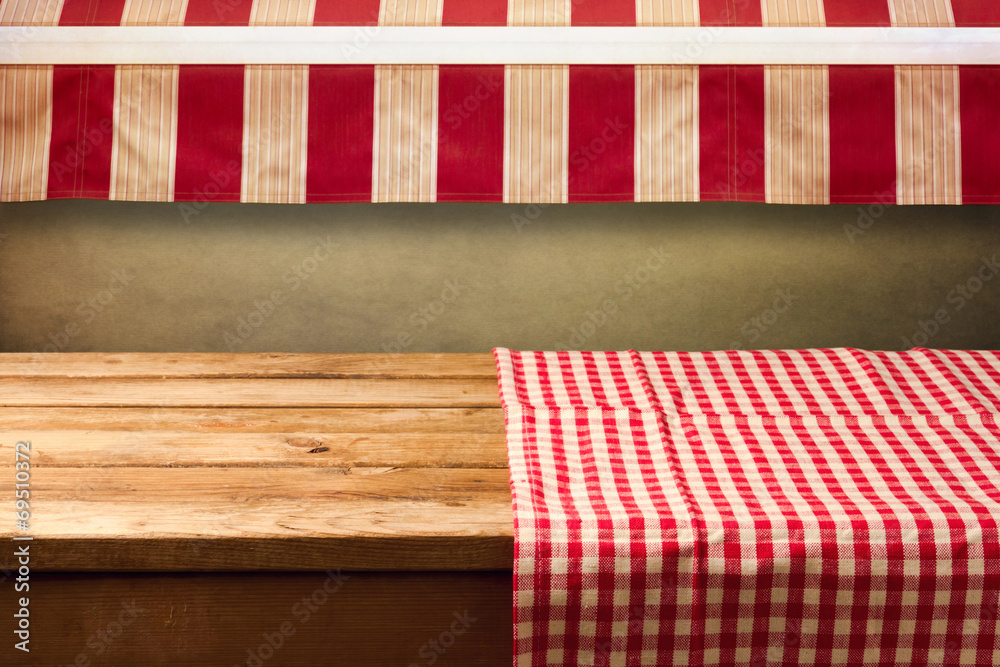 Obraz premium Empty wooden table covered with red checked tablecloth