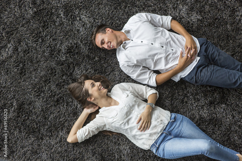 Fototapeta Naklejka Na Ścianę i Meble -  Young couple relaxing on the carpet