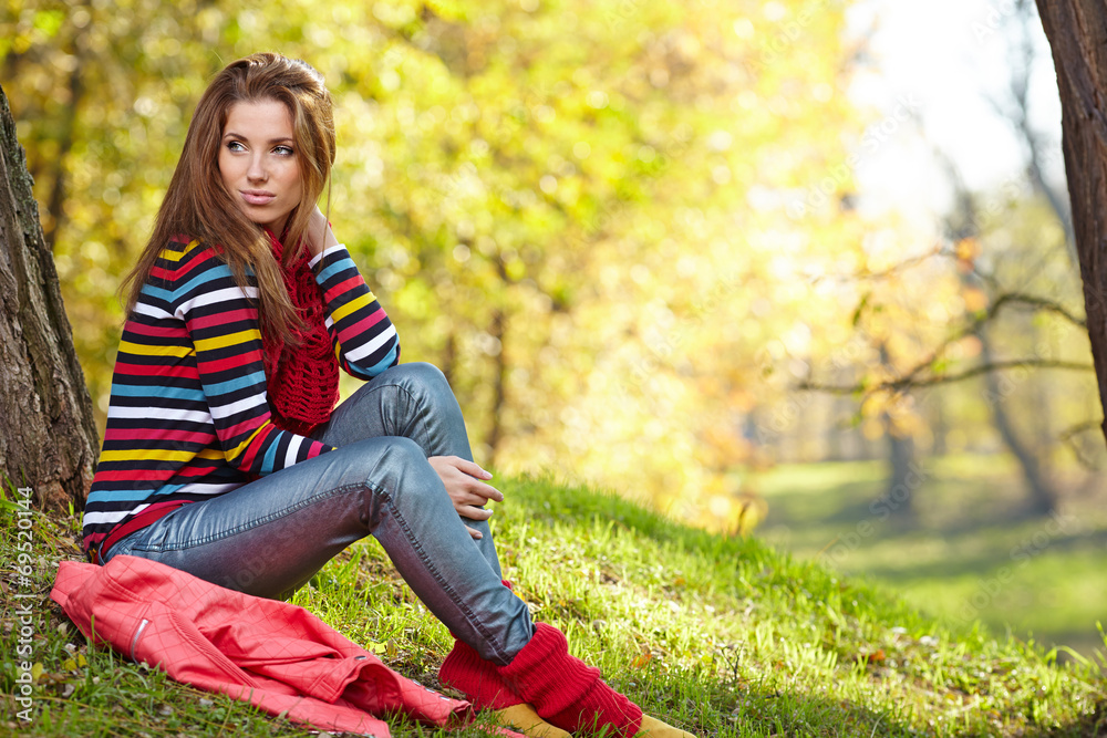 Fall woman relaxing happy in autumn forest foliage sitting Fall woman relaxing happy in autumn forest foliage sitting