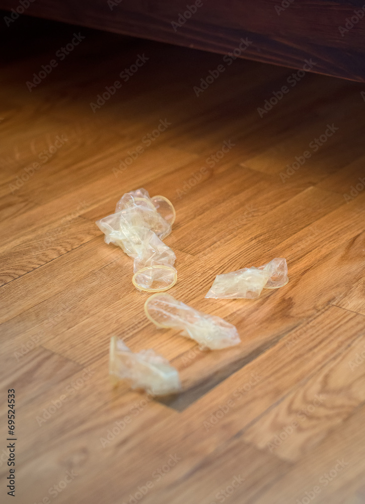 Messy room in the hotel, condoms on the floor. Stock Photo Adobe Stock
