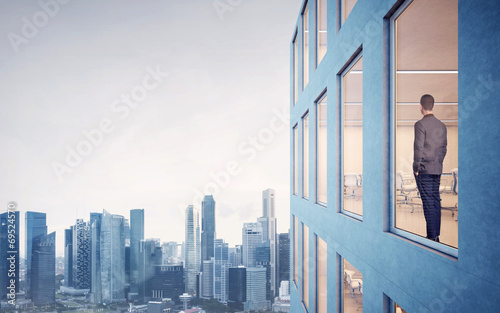 Business man looking megalopolis through window © SFIO CRACHO