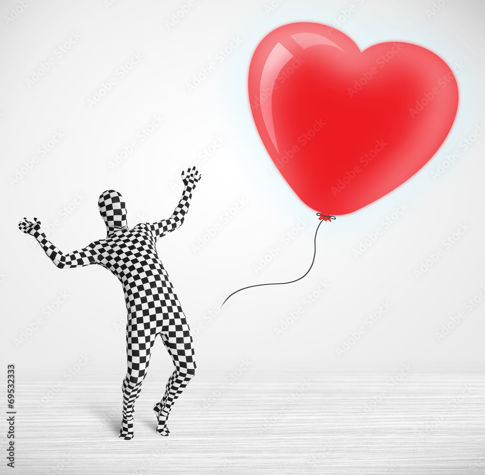 Fototapeta premium Cute guy in morpsuit body suit looking at a balloon shaped heart