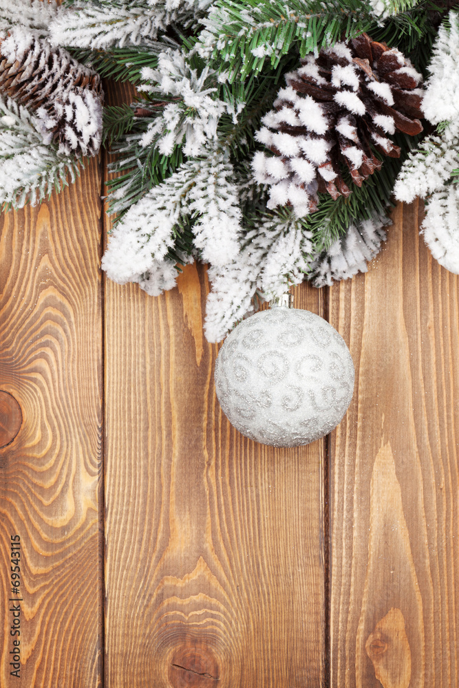 Fototapeta premium Christmas fir tree with snow and bauble on rustic wooden board
