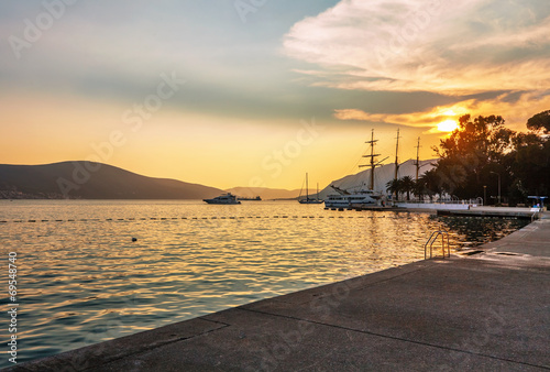 Sailing boats in marina at sunset.