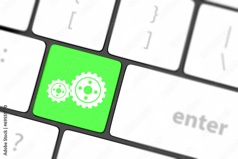 cogwheel gear mechanism on button on white computer keyboard. cogwheel gear mechanism on button on white computer keyboard.