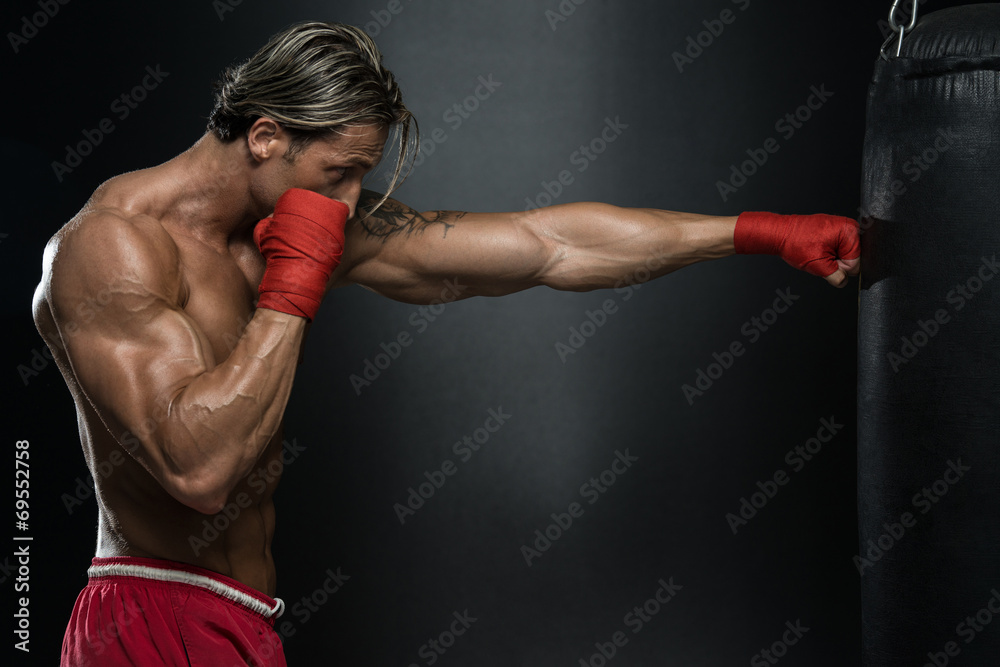 Mature Man Exercising Bag Boxing In Studio